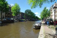 阿姆斯特丹1637: Historic Canal View Suites的河的一边有一条船