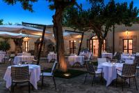 马尔萨拉Hotel Baglio Oneto dei Principi di San Lorenzo - Luxury Wine Resort的户外用餐区配有白色的桌椅