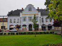 尼尔巴托尔Kakukk Panzió的一座白色的大建筑,前面有一个公园