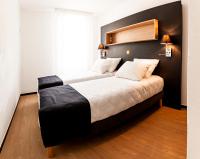 格勒诺布尔Apparthotel Le Hüb Grenoble的卧室里有一张带黑色床头板的大床