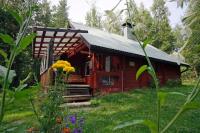 Kosula哈提图维特山林小屋的花园中的一个红色小小屋,种着鲜花
