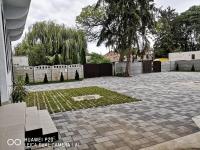 尼尔巴托尔Kakukk Panzió的砖砌的庭院,有栅栏和树
