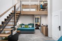 干尼亚Lignum Suites Chania的客厅设有蓝色沙发,位于楼梯下