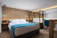 干尼亚Lignum Suites Chania的一间卧室配有一张床、一张书桌和一个浴缸