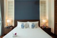 曼谷The Rose Residence, Bangkok的一张床上有两只蓝色和白色花瓶的床