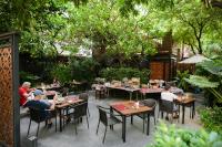 曼谷The Rose Residence, Bangkok的一群人坐在餐厅的桌子旁