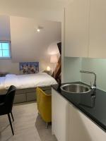 巴登smartroom The Residence la Cittadella Baden的带水槽的厨房和房间里的一张床