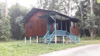 瓜拉江沙Chalet Kampong Guar, Manong的一条红色小屋,在道路前设有蓝色楼梯