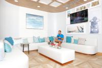 格尔夫海岸Hotel Indigo Orange Beach - Gulf Shores by IHG的一位女士坐在客厅的沙发上
