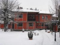 科普里夫什迪察Family Hotel Kalina的前面的红色房子,地面上有雪