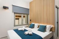 干尼亚Lignum Suites Chania的卧室里有一张白色的大床，配有蓝色的枕头