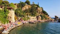 安塔利亚Saye Konak Hotel &#39; Kaleiçi&amp;Oldtown&#39;的有遮阳伞和人在水中的海滩