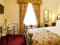 法利Filey Grange Guest House的一间带床、桌子和窗户的酒店房间