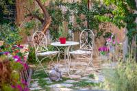 SpartýlasLorantina Luxury Sea View Holiday House close to Barbati &amp; Ipsos Beach with Starlink WiFi的花园里的两把椅子和一张桌子