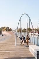 华盛顿InterContinental - Washington D.C. - The Wharf by IHG的两个人坐在水边的木板路上