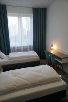 科沙林Stary Koszalin Hostel &amp; Hotel Services的有两张床、一张书桌和一扇窗户的房间