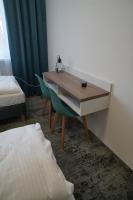 科沙林Stary Koszalin Hostel &amp; Hotel Services的一张桌子和椅子,位于一个床的房间