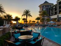 德斯坦Henderson Beach Resort的酒店旁的游泳池配有桌椅