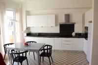尼斯Les Gérardines by EnjoyNice, 3-room with Airco and balcony的一间带桌椅的厨房和一间带白色橱柜的厨房