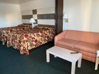 大洋城Fish Tales Boardwalk Inn &amp; Ocean Mecca Motel的配有床和沙发的酒店房间