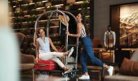 迪拜Revier Hotel - Dubai的两个女人坐在行李车上