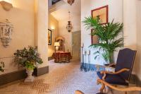 塞维利亚Casa de la Moneda Residences Sevilla的走廊上设有植物、椅子和镜子