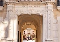 塞维利亚Casa de la Moneda Residences Sevilla的建筑中的拱门,上面有标志