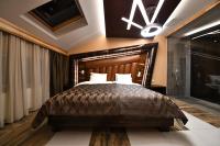 洛兹尼察Hotel Havana Loznica的卧室里有一张带木质床头板的大床