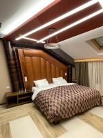 洛兹尼察Hotel Havana Loznica的卧室里有一张带木质床头板的大床