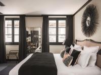 马赛Maisons du Monde Hôtel &amp; Suites - Marseille Vieux Port的卧室里有一张大床，配有黑白枕头
