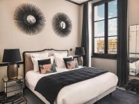 马赛Maisons du Monde Hôtel &amp; Suites - Marseille Vieux Port的卧室配有一张床铺,墙上挂有两面镜子