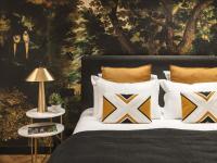 马赛Maisons du Monde Hôtel &amp; Suites - Marseille Vieux Port的卧室里有一张床，上面有枕头和一幅画