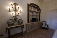 埃尔科拉诺Casa Raiola Ercolano Luxury Rooms &amp; Spa的一间设有镜子、电视和椅子的房间