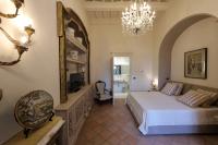 埃尔科拉诺Casa Raiola Ercolano Luxury Rooms &amp; Spa的一间带大床和吊灯的卧室