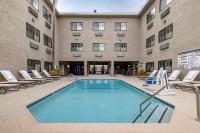 安纳海姆Best Western Plus Park Place Inn - Mini Suites的一座带躺椅的建筑前的游泳池