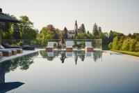 德意志兰茨贝格Boutiquehotel DAS ZEITWERT的一个人站在游泳池旁边的露台上
