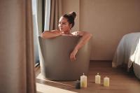 德意志兰茨贝格Boutiquehotel DAS ZEITWERT的女人坐在带蜡烛的浴缸里