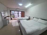 合艾Khoksametchun Hostel的一间有两张床和厨房的酒店房间