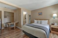 BurneyShasta Pines Motel &amp; Suites的配有一张大床和一张书桌的酒店房间