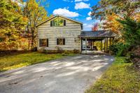 加特林堡Barenberg Cabin - Secluded Unobstructed Panoramic Smoky Mountains View with Two Master Suites, Loft Game Room, and Hot Tub的一栋前面有车道的房子