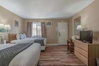 BurneyShasta Pines Motel &amp; Suites的一间有两张床和一台平板电视的酒店房间