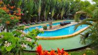 福尔图纳Hotel Heliconias Nature Inn &amp; Hot Springs的度假村里的游泳池，配有椅子和鲜花