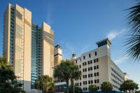 默特尔比奇Courtyard by Marriott Myrtle Beach Oceanfront的一座前面有棕榈树的建筑