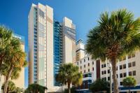 默特尔比奇Courtyard by Marriott Myrtle Beach Oceanfront的一座前面有棕榈树的高楼