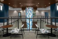 默特尔比奇Courtyard by Marriott Myrtle Beach Oceanfront的大堂设有椅子和大型雕塑