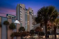 默特尔比奇SpringHill Suites by Marriott Myrtle Beach Oceanfront的一座前面有棕榈树的大楼