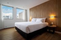 圣保罗Sooz Hotel Collection的有一张大床和两扇窗户的酒店房间