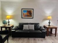 佩吉Lake Powell Motel &amp; Apartments的客厅里一张黑色皮沙发,配有两盏灯