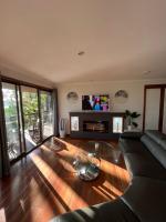 棕榈滩Palm beach Sydney, Modern home with water view的配有沙发和平板电视的客厅
