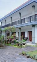 沙努尔LA Homestay sanur的一座白色的大建筑,前面设有一个庭院